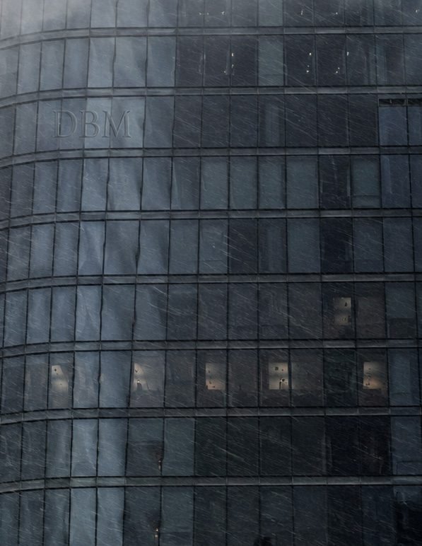 Rain and wind striking the glass facade of a high-rise curtain wall during a storm
